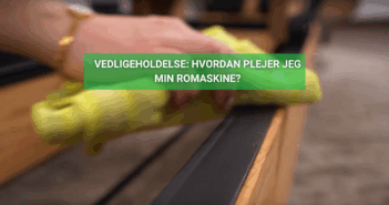 Hånd med gul klud tørrer skinne på romaskine i træ