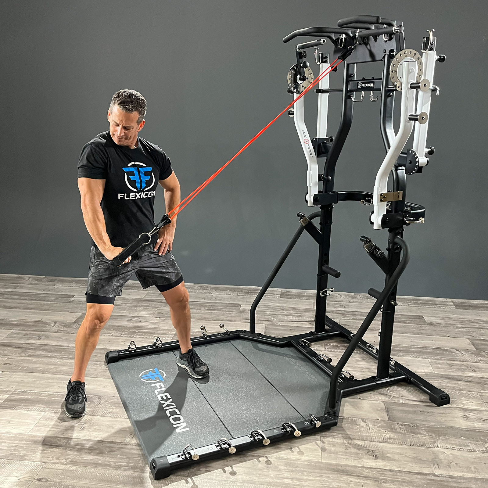 Person udfører stående kabeltræk med elastik på Taurus Flexicon multimaskine i fitnessrum.