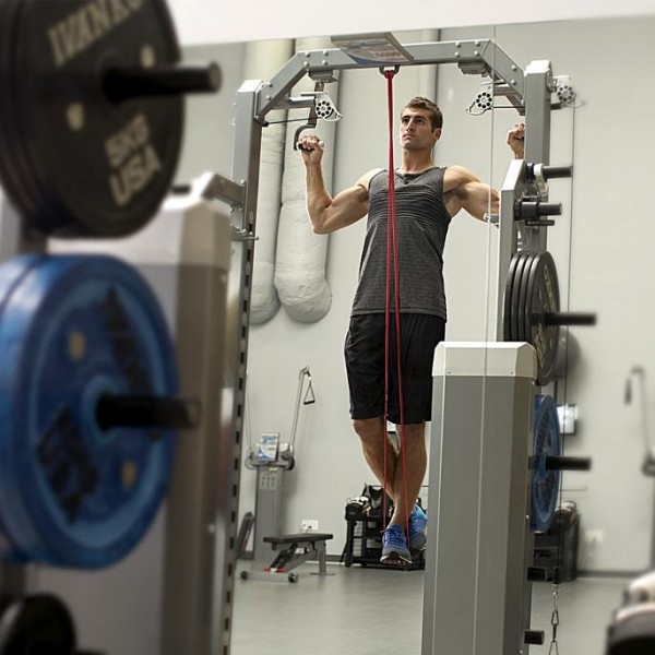 Person laver pull-ups med SKLZ Pro Bands træningselastik som assistance.